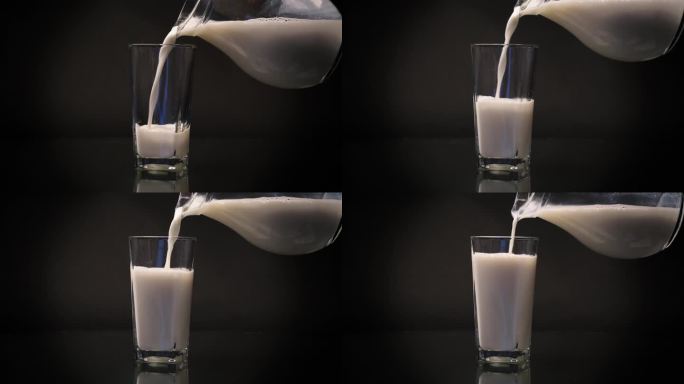 新鲜的天然牛奶从醒酒器中倒入玻璃杯