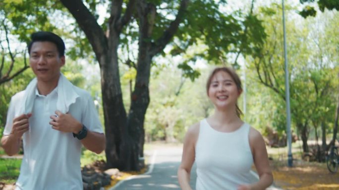 一对亚洲夫妇早上在公园慢跑