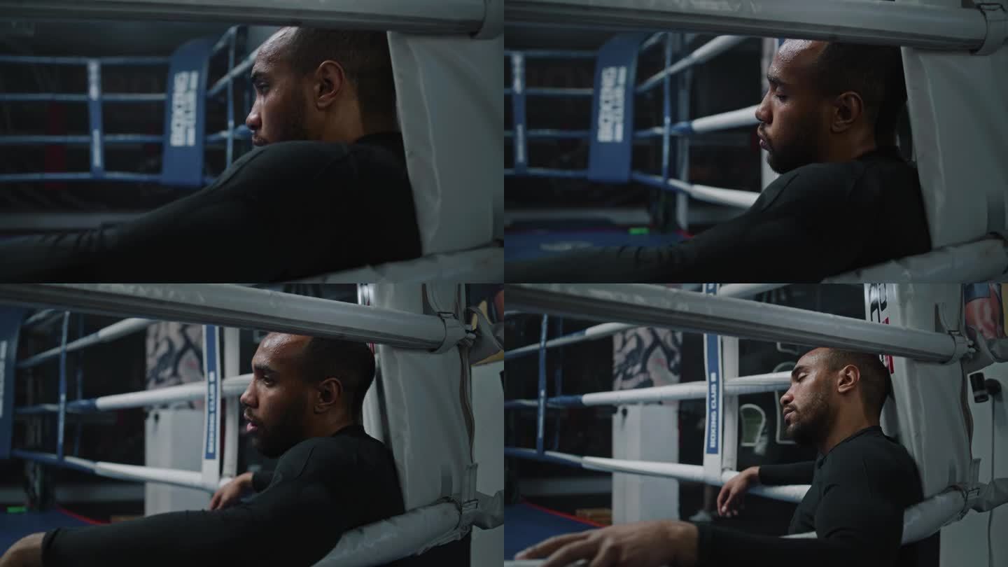 疲惫的非裔美国拳击手坐在拳击台的角落里