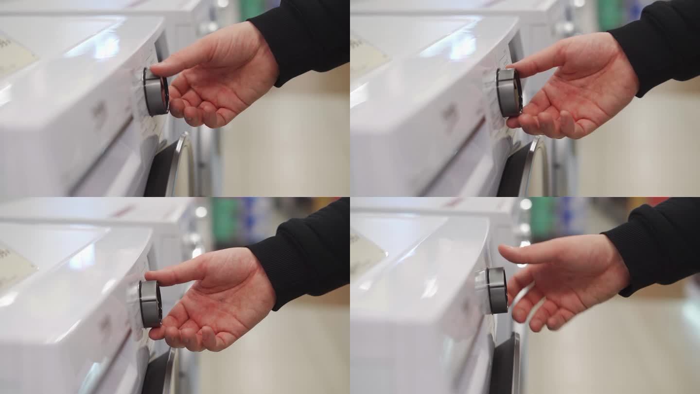一个白人男子的手在调节洗衣机的旋钮