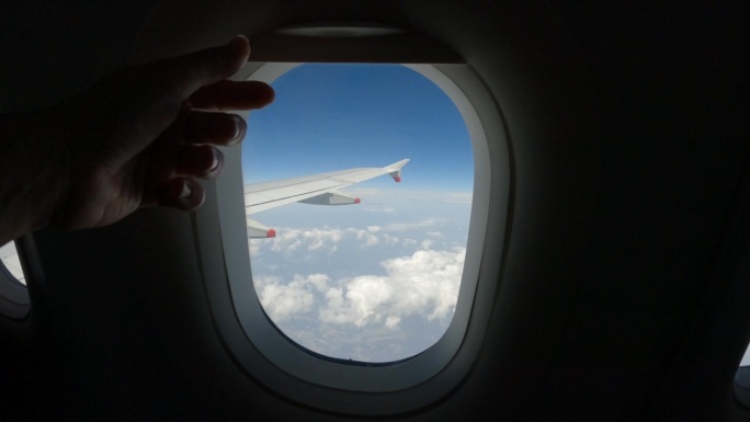 镜头:飞机乘客在飞行过程中拉上飞机窗户上的窗帘