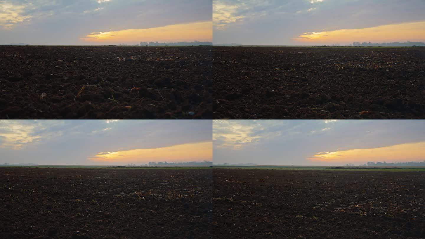夕阳下，耕过的田野映衬着天空的宁静景象