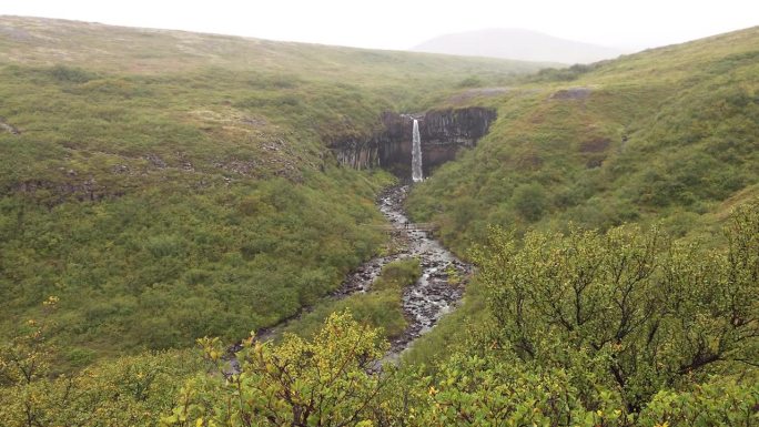 冰岛斯卡夫塔费尔国家公园的斯瓦蒂福斯瀑布在一个雨天的广角视图。