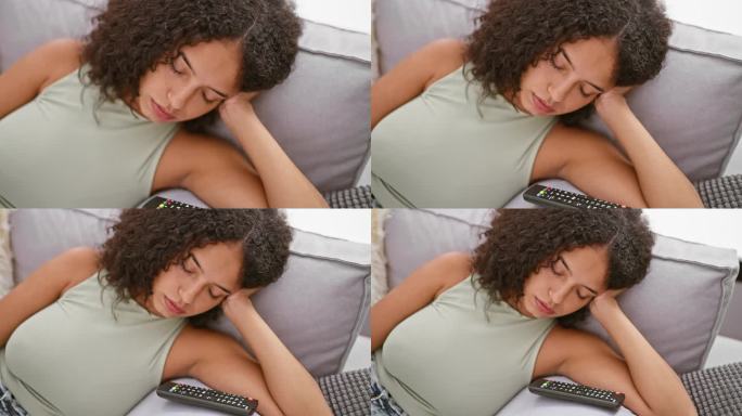 筋疲力尽的年轻西班牙女子躺在沙发上，在家里客厅舒适的背景下睡得很熟，把遥控器留给了急需休息的人