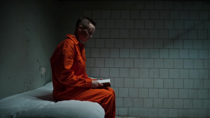 女囚犯在牢房里读圣经和祷告