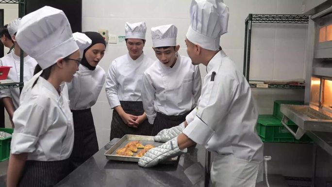 亚洲主厨在烹饪课上教一群学生如何烤面包