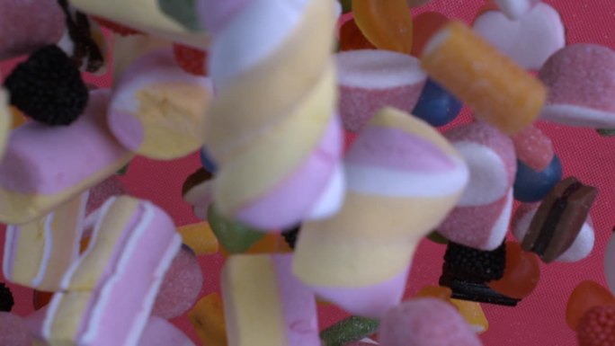 五颜六色的糖果，包括棉花糖，扔在空中，在超级慢动作1000帧/秒的微缩