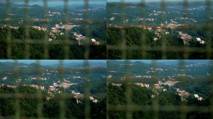 桥上的金属网，防止悬崖，作为防止自杀的屏障，通常与失望、离婚和破产有关。阿尔卑斯山上一座城市的背景。