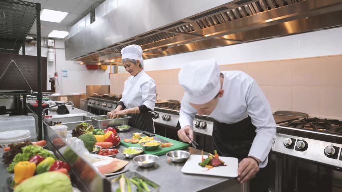 提升厨艺:亚洲高年级女学生在烹饪课上展示了对食物装饰的掌握