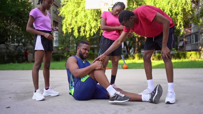 年轻的黑人男子在打篮球时腿部受伤，感到疼痛