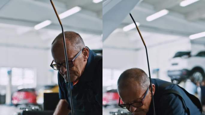 男机械师在汽车修理厂检查汽车发动机