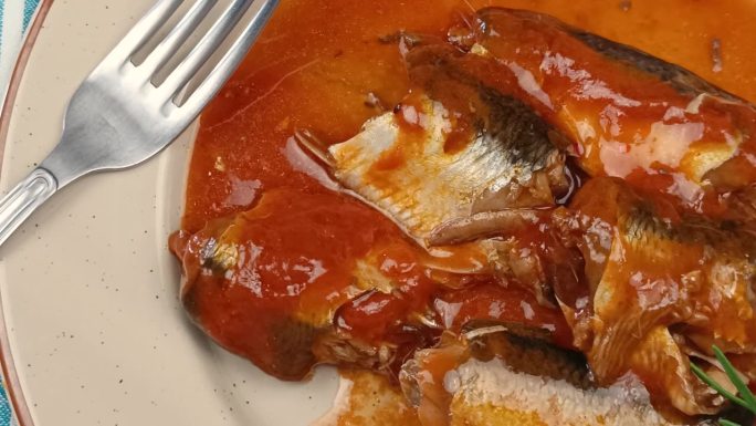 一盘配番茄酱的沙丁鱼，特写