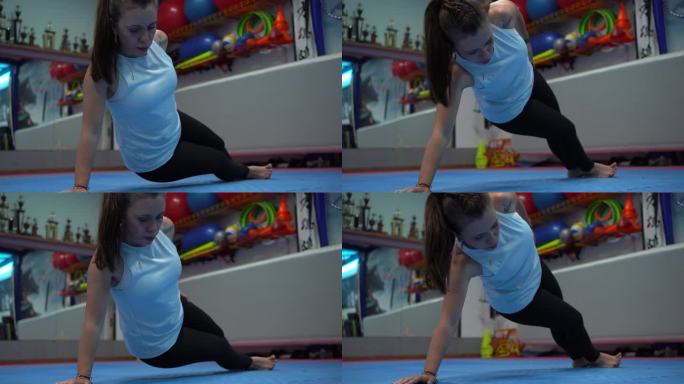 一个成熟的女人在健身房做侧平板支撑