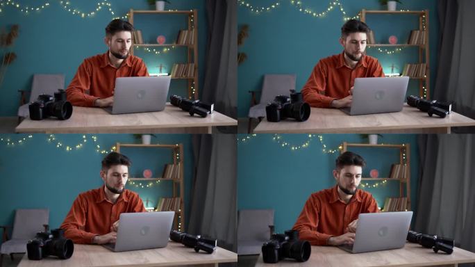 男摄影师把存储卡里的照片转移到笔记本电脑上，帅哥在家里办公室用相机在笔记本电脑上工作