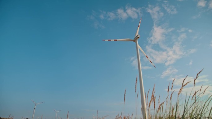 SLO MO草原巨人:风力涡轮机在蔚蓝的天空下升起