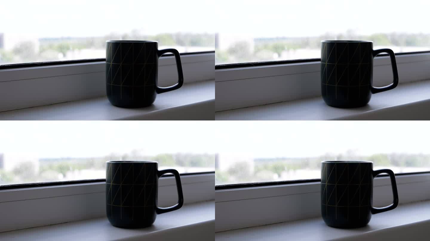 剪影，站在窗边的窗台上喝一杯热咖啡或茶