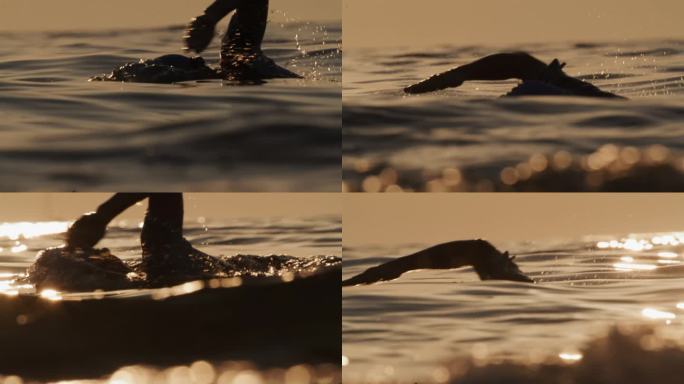 慢动作拍摄运动的女人在日落期间在海洋游泳。有目标的女人。