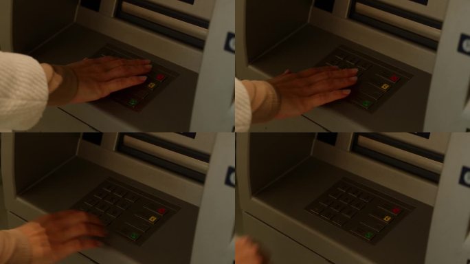 在银行自动柜员机键盘上输入PIN码的手特写