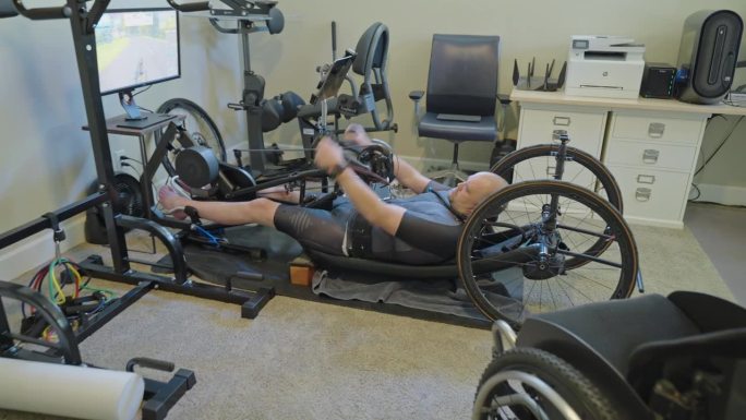 适应性运动员在家庭健身房使用手动自行车