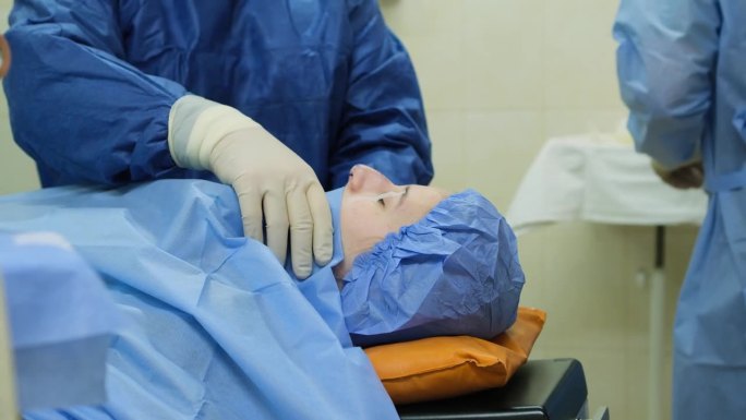 一个女孩躺在手术台上，全身麻醉。