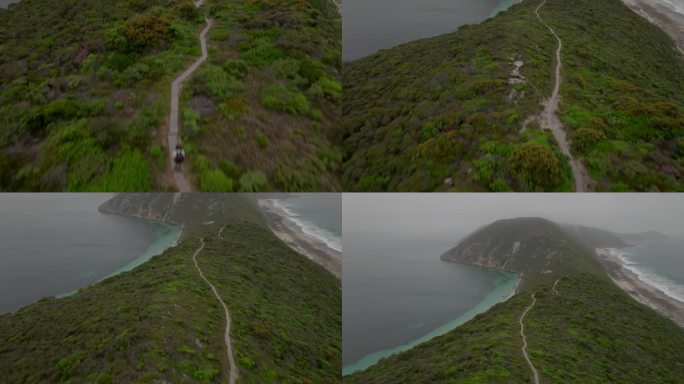 航拍照片，倾斜向上，露出海岬的山脊线，延伸6公里，进入海洋，进入雾和薄雾。