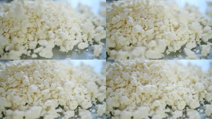 奶牛厂生产过程中，易碎的白色牛奶凝块堆积在一起的特写镜头。发酵乳制品含有许多对人体有益的物质。