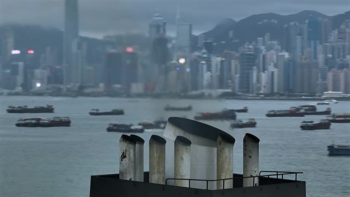 从货船的烟囱中喷出的热烟。视差无人机拍摄的香港天际线为背景