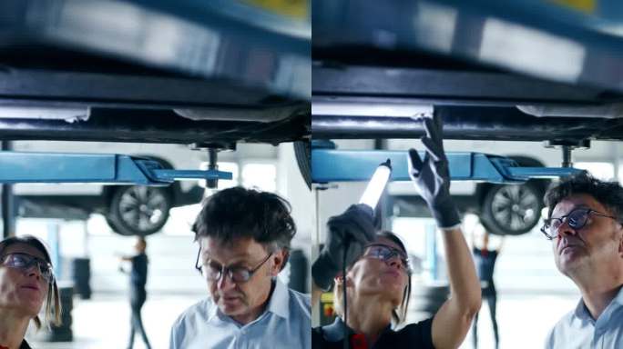汽车修理工和经理拿着数码平板电脑在修理厂检查汽车