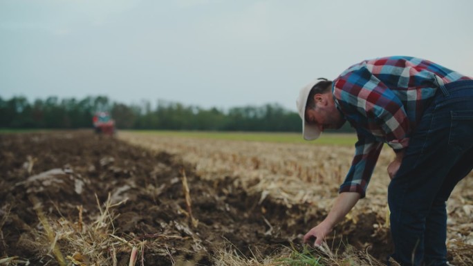 男农民在有机农场工作时分析土壤
