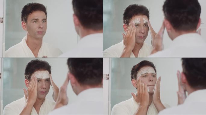年轻人在镜子前用洁面泡沫洗脸
