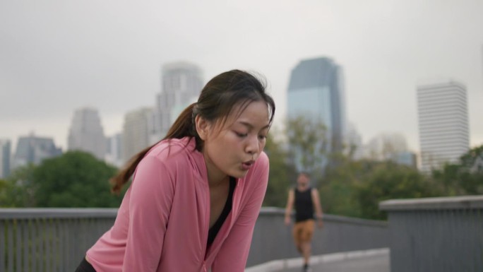 在激烈的跑步训练后，疲惫的女子正在休息