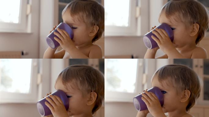 用紫色杯子喝水的小孩