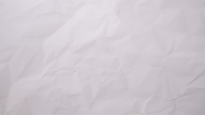定格运动:背景是柔软的白色皱巴巴的纸，为纪录片视频创造了精致的纹理背景