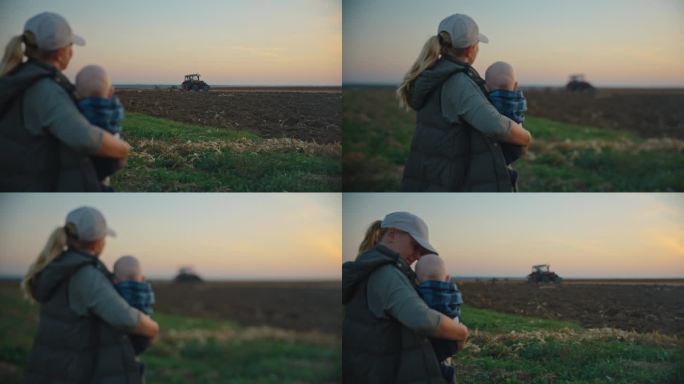 在夕阳的背景下，母亲带着儿子看着拖拉机犁地