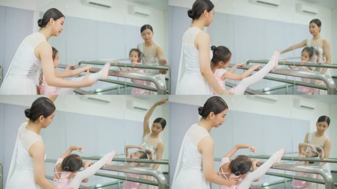 芭蕾舞老师在演播室帮助女学生在杠上伸展姿势。