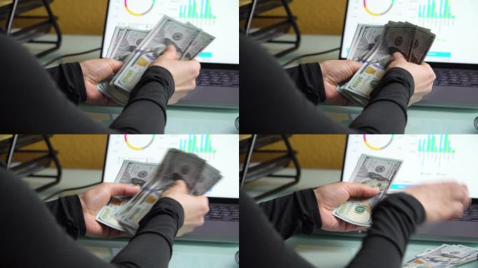 4K特写镜头，女性的手在笔记本电脑屏幕前数着100美元的钞票。家庭理财概念