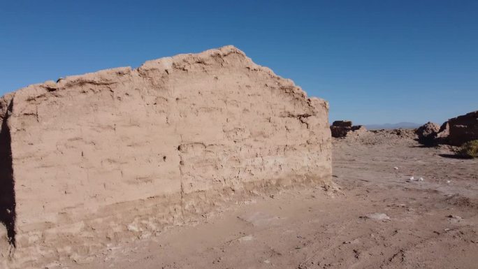 破败的泥砖土坯建筑在干燥的沙漠景观与清澈的蓝天没有云
