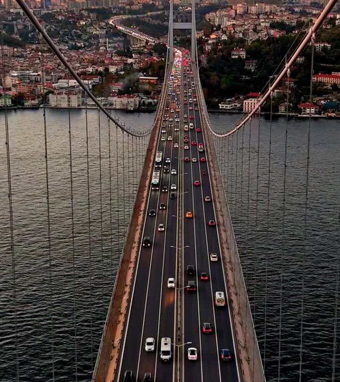 空中的博斯普鲁斯大桥和伊斯坦布尔的欧洲一侧:空中的奥德赛7月15日烈士桥和金融区的摩天大楼黄昏