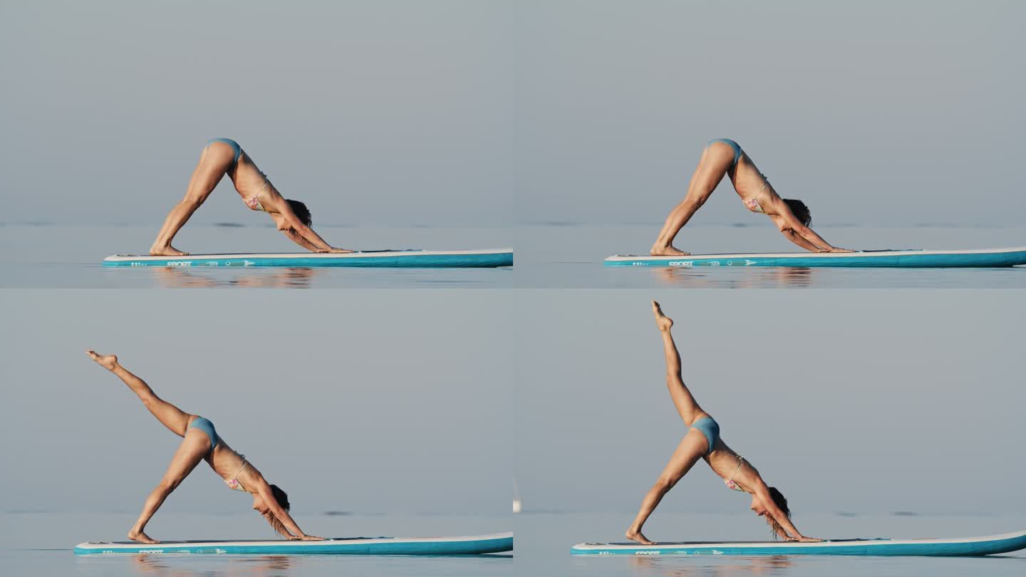 在阳光明媚的日子里，穿着比基尼在冲浪板上练习瑜伽的活跃女性的慢镜头