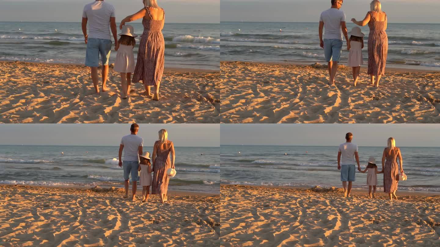 日落时分，一家人在海边的沙滩上散步。暑假，旅游，旅游