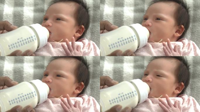 新生儿的脸从奶瓶里喝牛奶新生儿躺在床上喝牛奶妈妈给她的宝宝喂奶可爱的婴儿宝宝在家里用爱喂奶新生儿概念