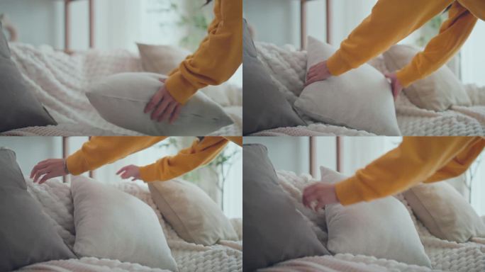女人的双手在舒适的沙发靠垫上排列枕头，在家里，家务和清洁的概念