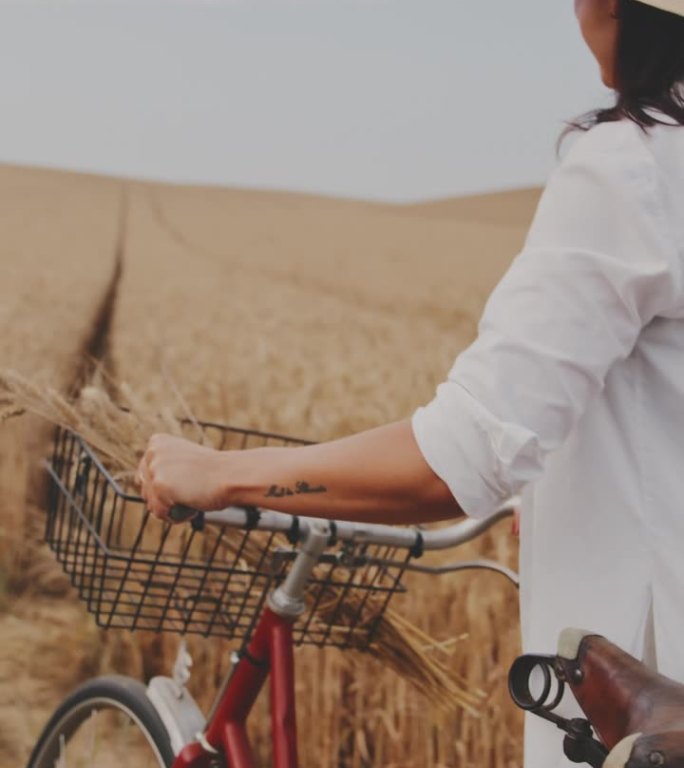 一名女子骑着自行车在金色的麦田里悠闲地散步