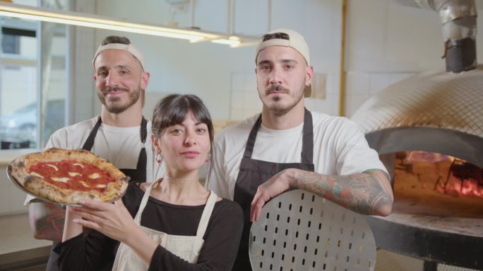 Team of Bakers Posing Together on Camera in Pizzer