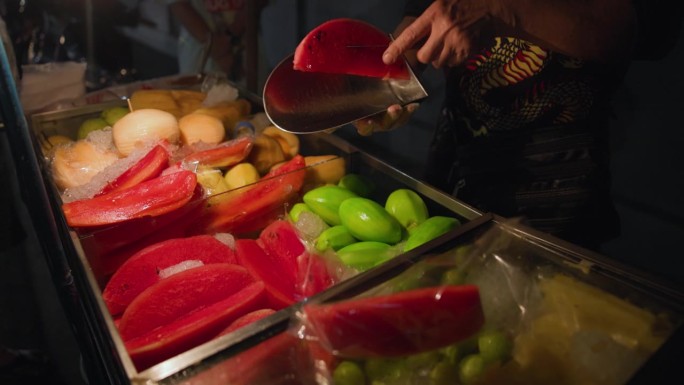 在泰国卖新鲜水果切片的街头小贩