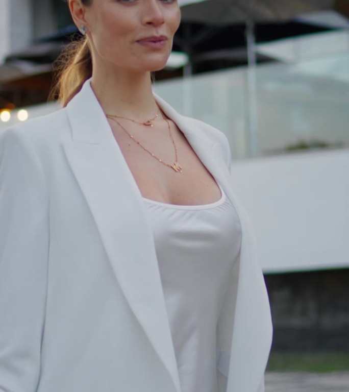 迷人的女商人享受晚上散步的垂直特写。女人漫步