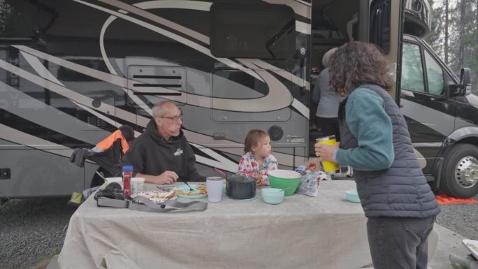 多代同堂的家庭在户外露营地吃早餐