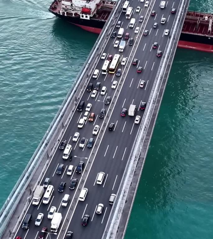 标志性的法提赫苏丹穆罕默德大桥上的空中交通和在桥下航行的集装箱船# istanbul - vibes