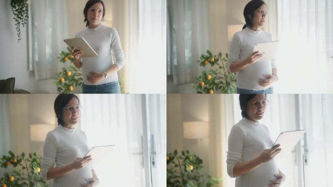 开朗的孕妇一边在家工作，一边用数码平板电脑聊天。