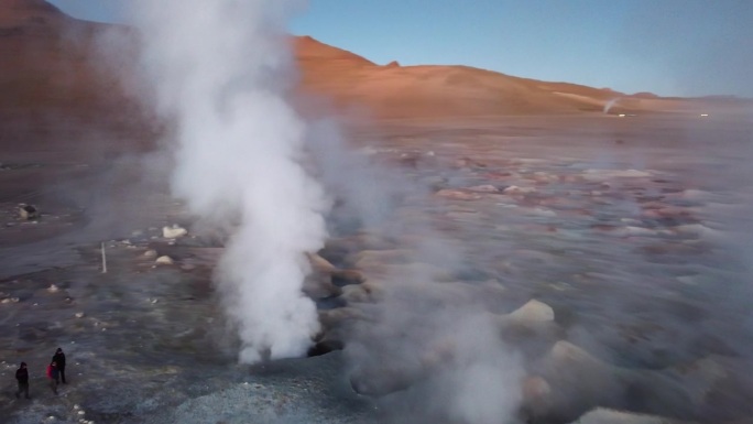 航空摄像机从地质间歇泉喷出的热气蒸汽中飞过